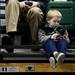 Canton resident Brayden Fleming, 3, plays games on a phone and waits for his mother's name to be called during the Eastern Michigan University Commencement on Sunday, April 28. Daniel Brenner I AnnArbor.com